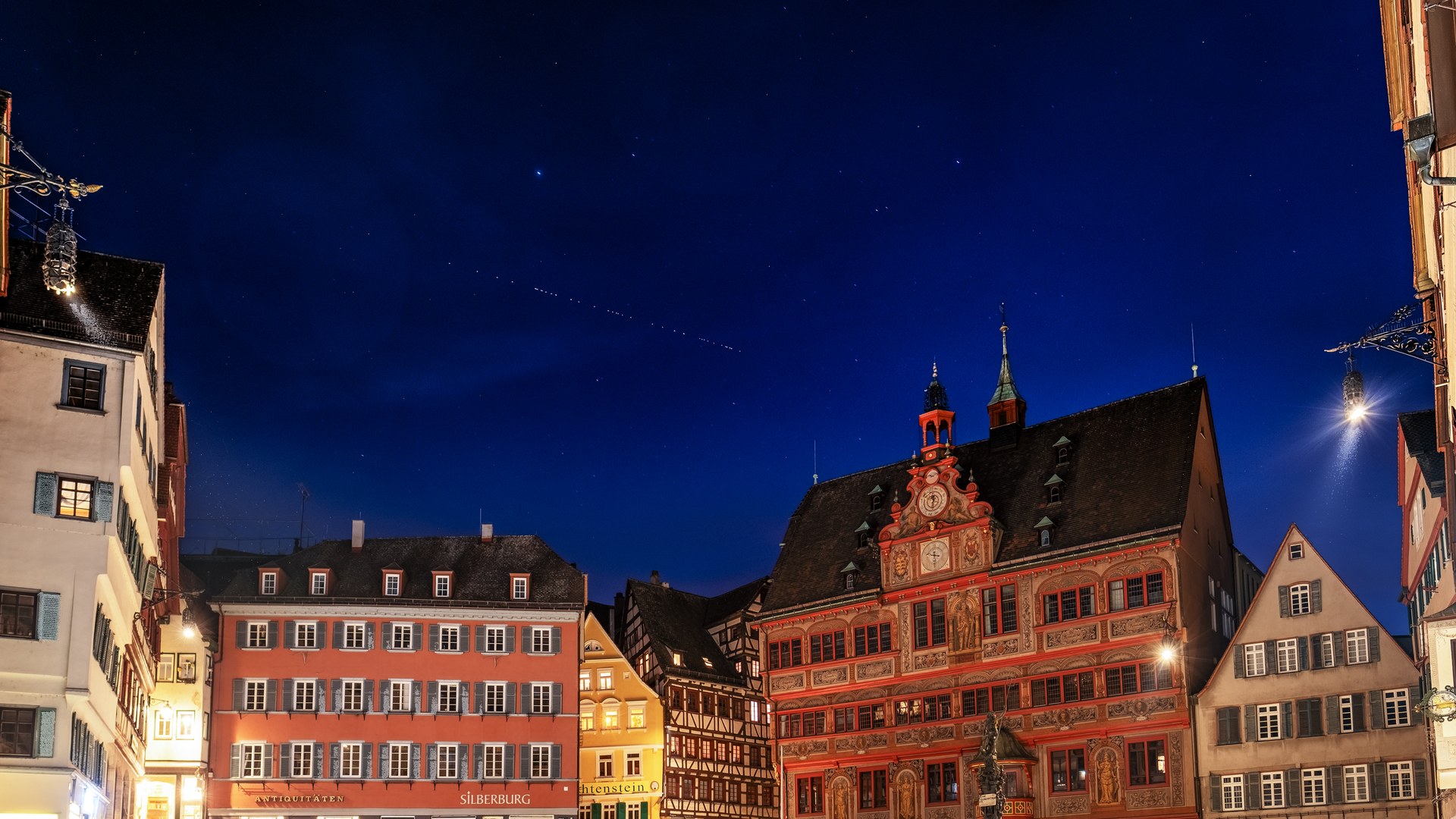 Starlink satellites streak across the night sky over a clock tower